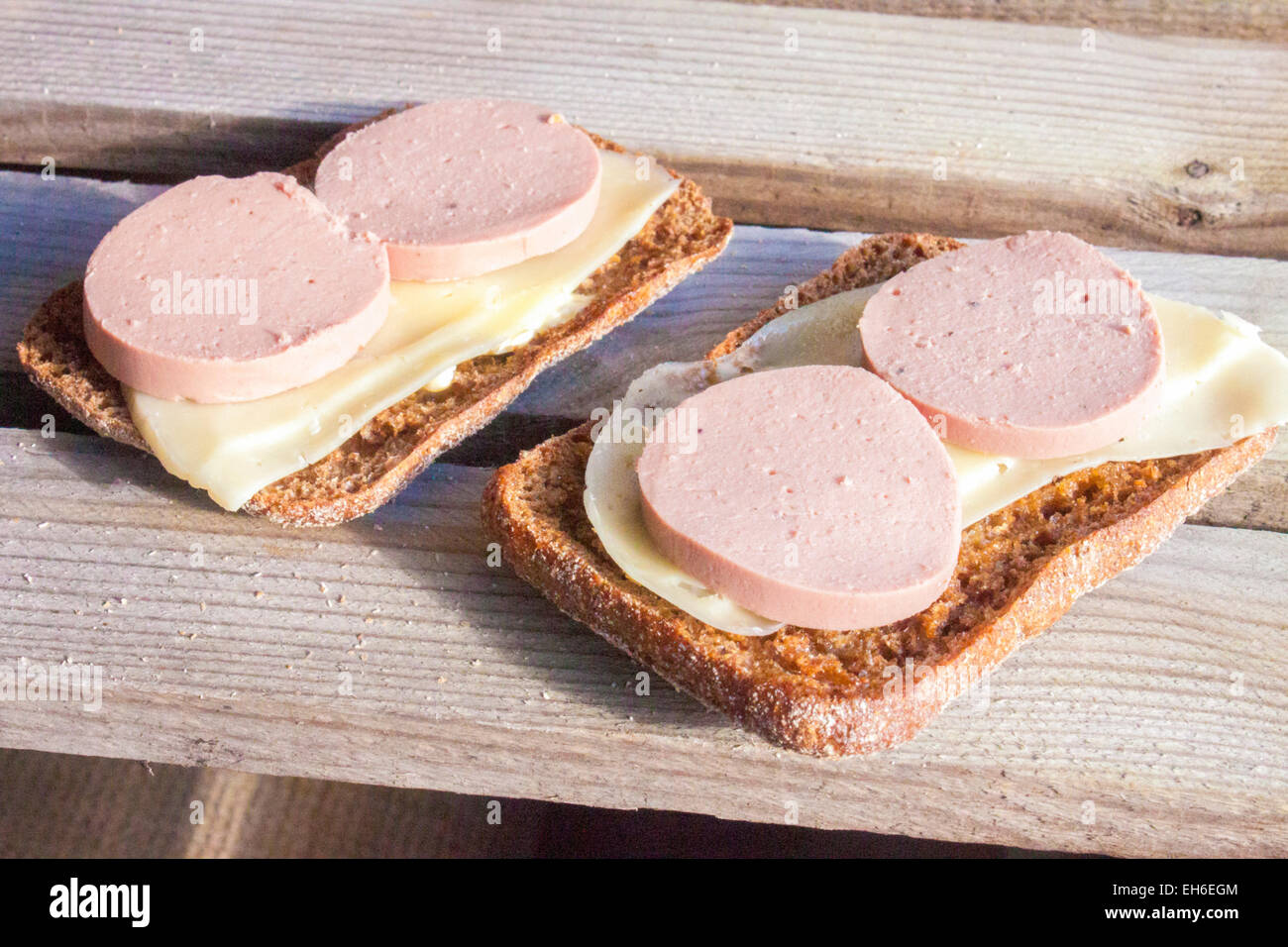 Salsiccia di fegato su pane di segale. Su sfondo di legno Foto Stock