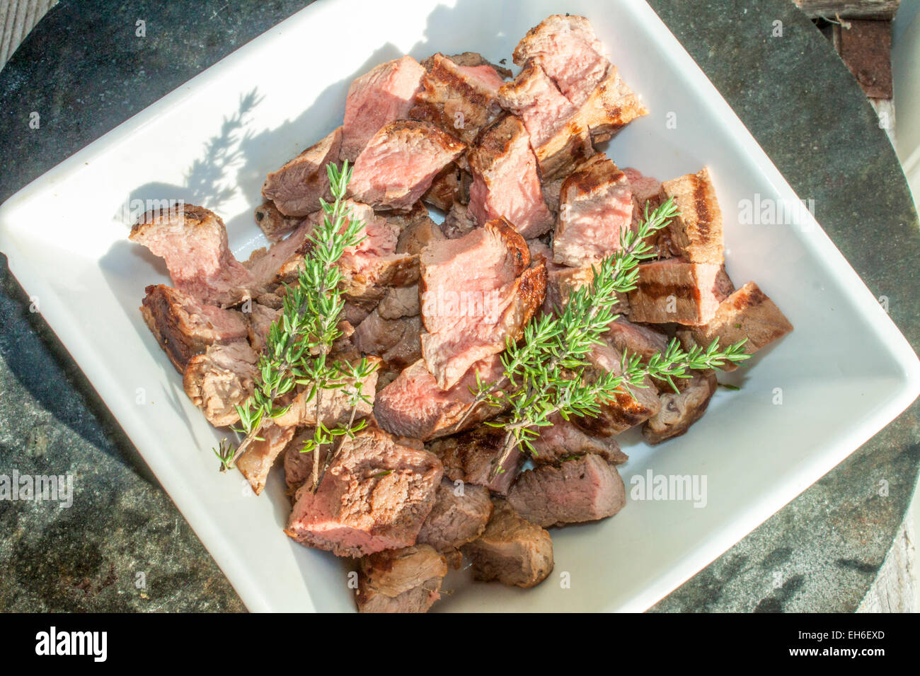 Tagliate a dadini la carne delle alci e timo, in una ciotola porslin Foto Stock