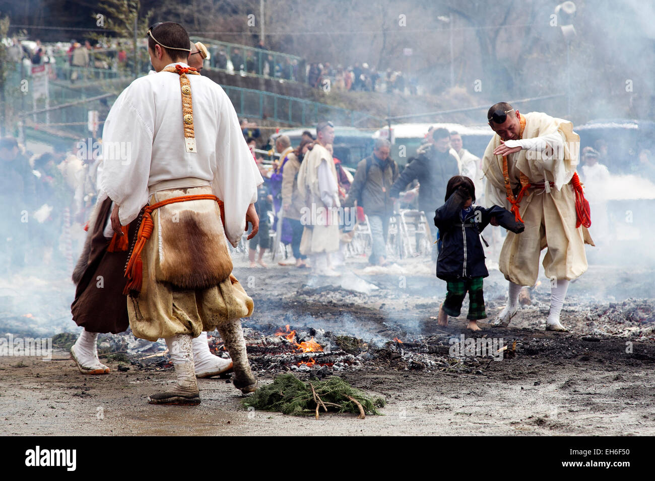 Tokyo, Giappone. 8 Marzo, 2015. Un bambino cammina con un praticante di Shugendo religione attraverso un percorso di braci durante il 'Hiwatari-matsuri' in Takao-san Yakuo-in Yuki-ji, Hachiōji-shi, Tokyo. La Shugendo seguaci anche chiamato 'Yamabushi' eseguire per ricevere la protezione dalla sfortuna, e per una buona salute e per pregare per la pace nel mondo. I visitatori possono partecipare alla fine della cerimonia per ricevere i benefici. Shugendo è un unica religione giapponese che mescola il Buddismo e l antico culto di montagna. Credito: Aflo Co. Ltd./Alamy Live News Foto Stock