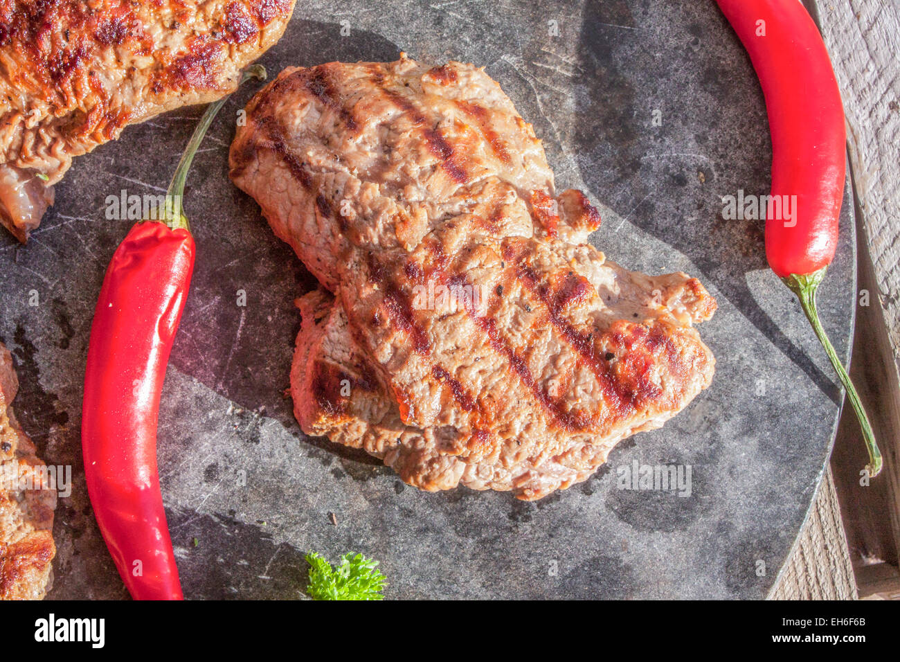 Moose bistecca di controfiletto, tra chilis, su un tavolo di pietra Foto Stock