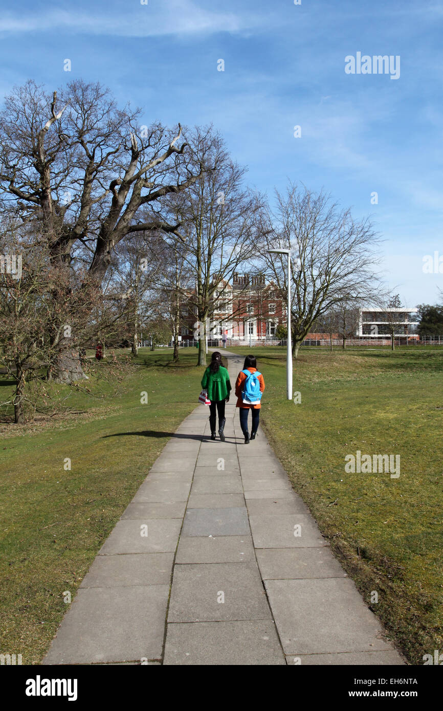 Gli studenti camminare sul parco dalla Università di Essex campus per Wivenhoe House Hotel, Wivenhoe Park, Colchester, Essex Foto Stock