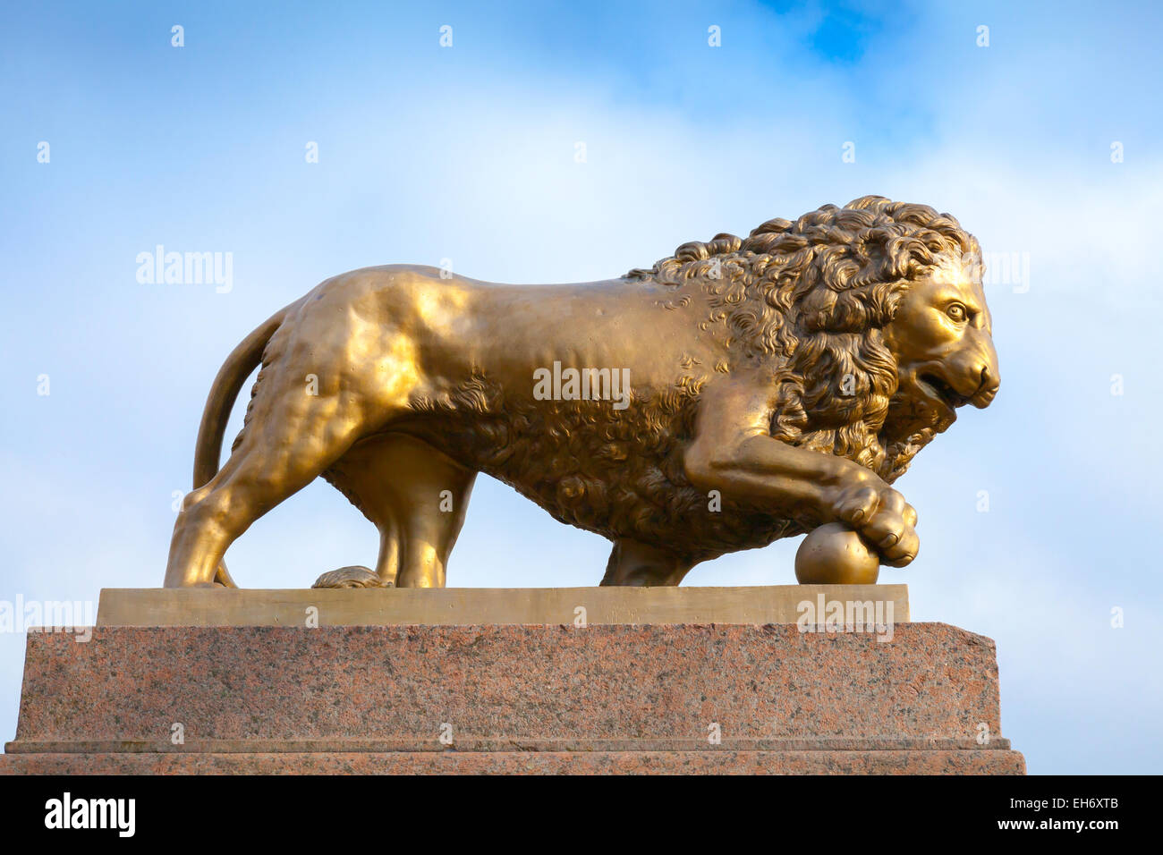 Leone di Bronzo con sfera, monumento su base di pietra oltre il cielo blu sullo sfondo Foto Stock