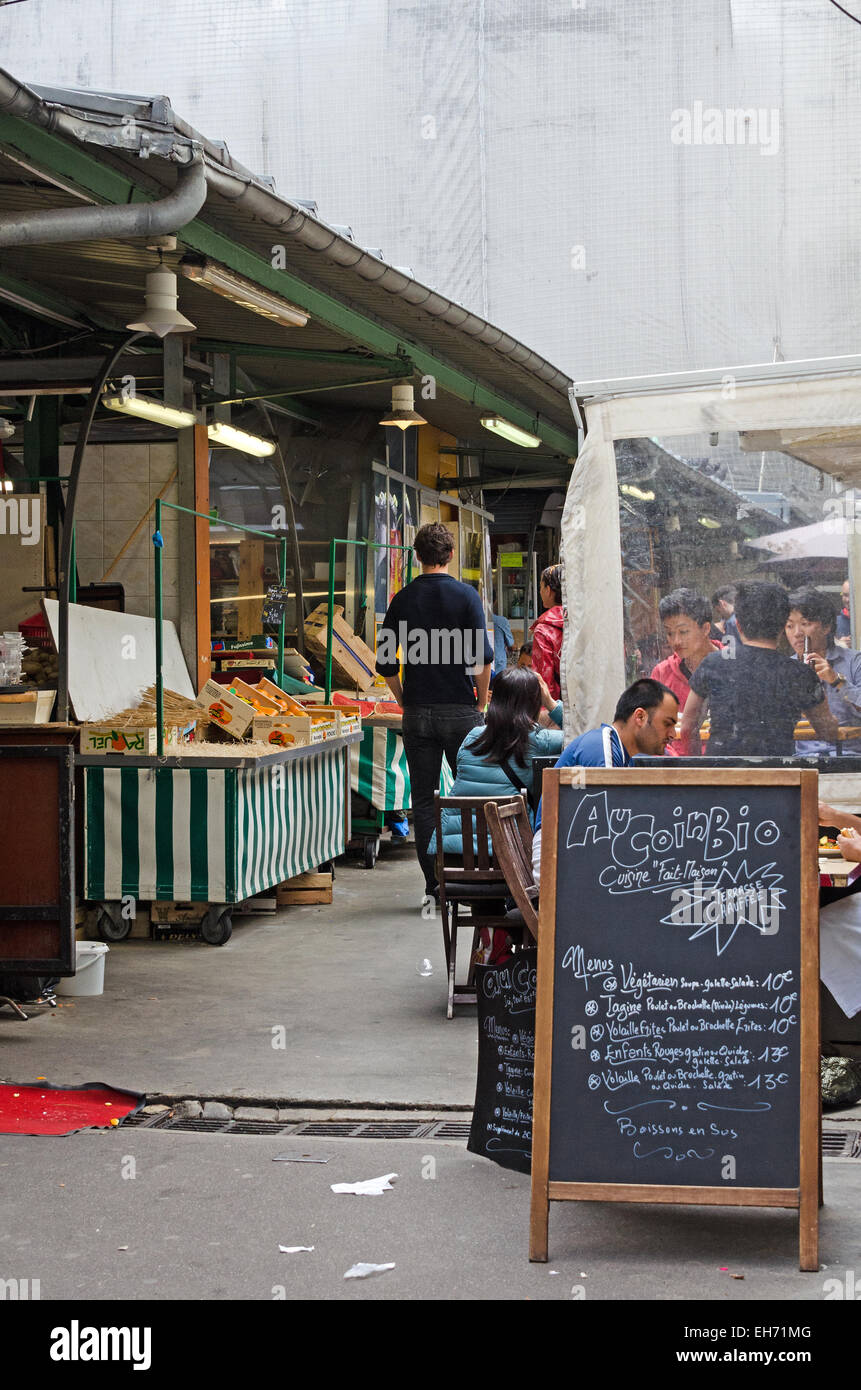 I clienti di mangiare in un organico cafe al marché des enfants Rouges, la più antica restante mercato coperto di Parigi. Foto Stock