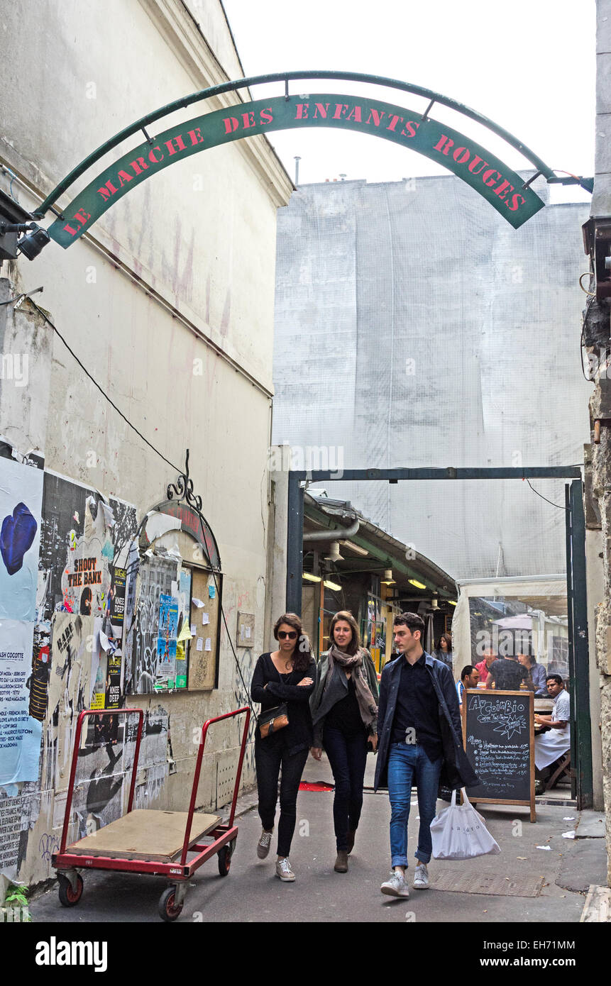 Un gruppo di amici passeggiate fuori del cancello di ingresso al marché des enfants Rouges, un organico di mercato che è il più antico mercato coperto di Parigi. Foto Stock