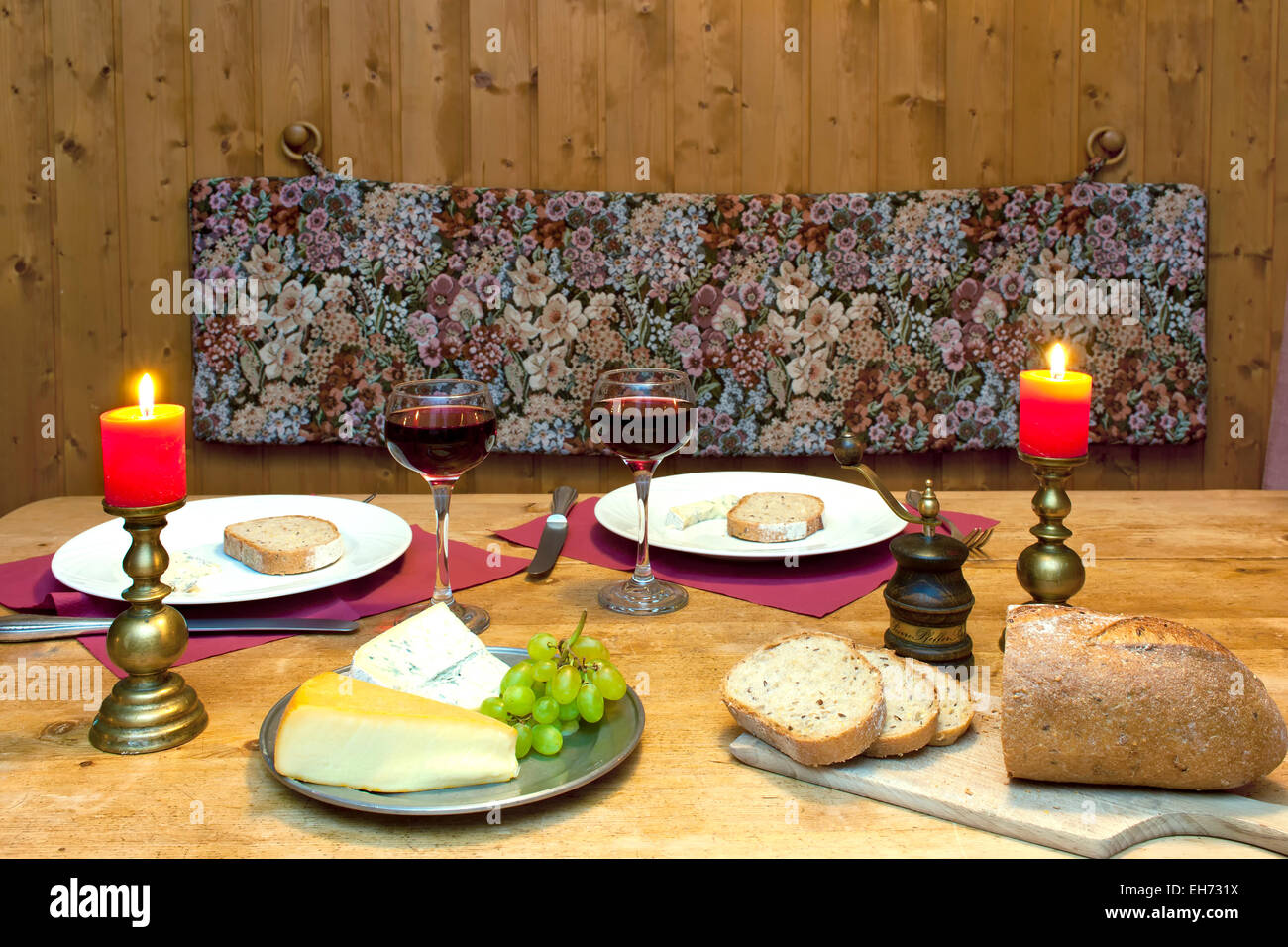 Cena intima messa in tavola con le candele e il vino servito in un romantico chalet di montagna nelle Alpi. Foto Stock