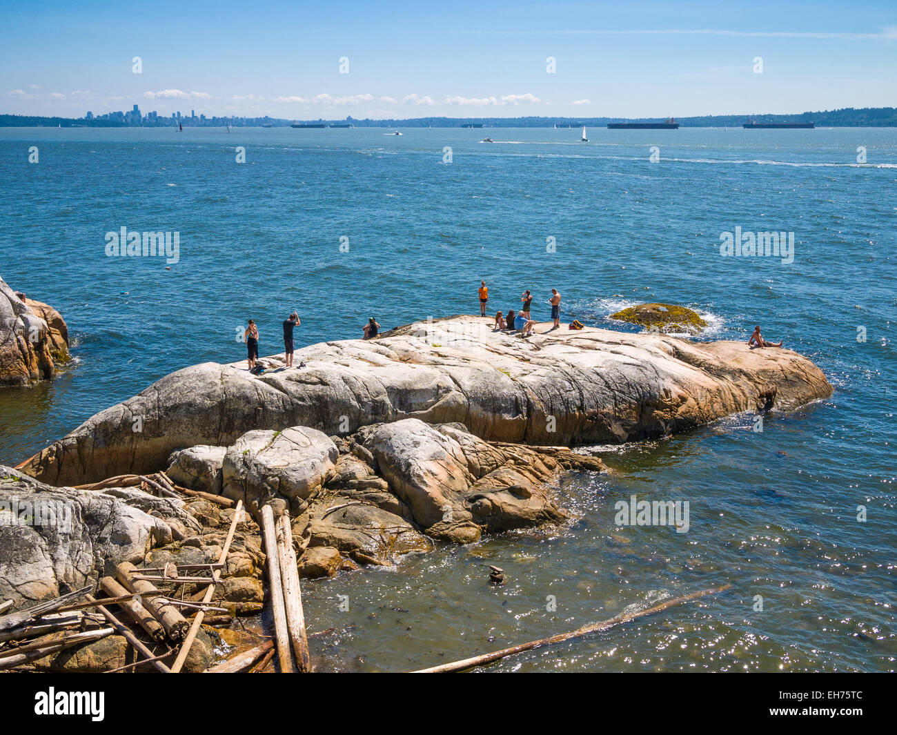 Nuotatori, beachcombers, lucertole da mare al Faro Park, punto Atkinson, West Vancouver, BC, Canada. Vancouver skyline della città Foto Stock