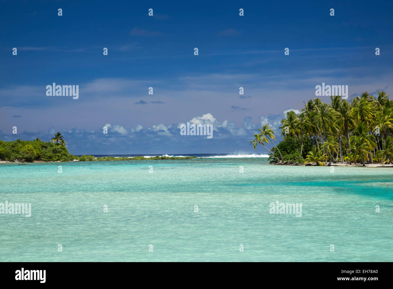 Atollo con acque blu e navigare all'orizzonte con palme Foto Stock