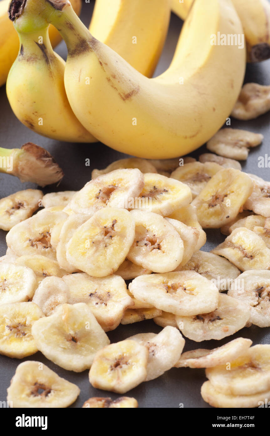 Dolce essiccato fette di banana con banane fresche in background. Foto Stock
