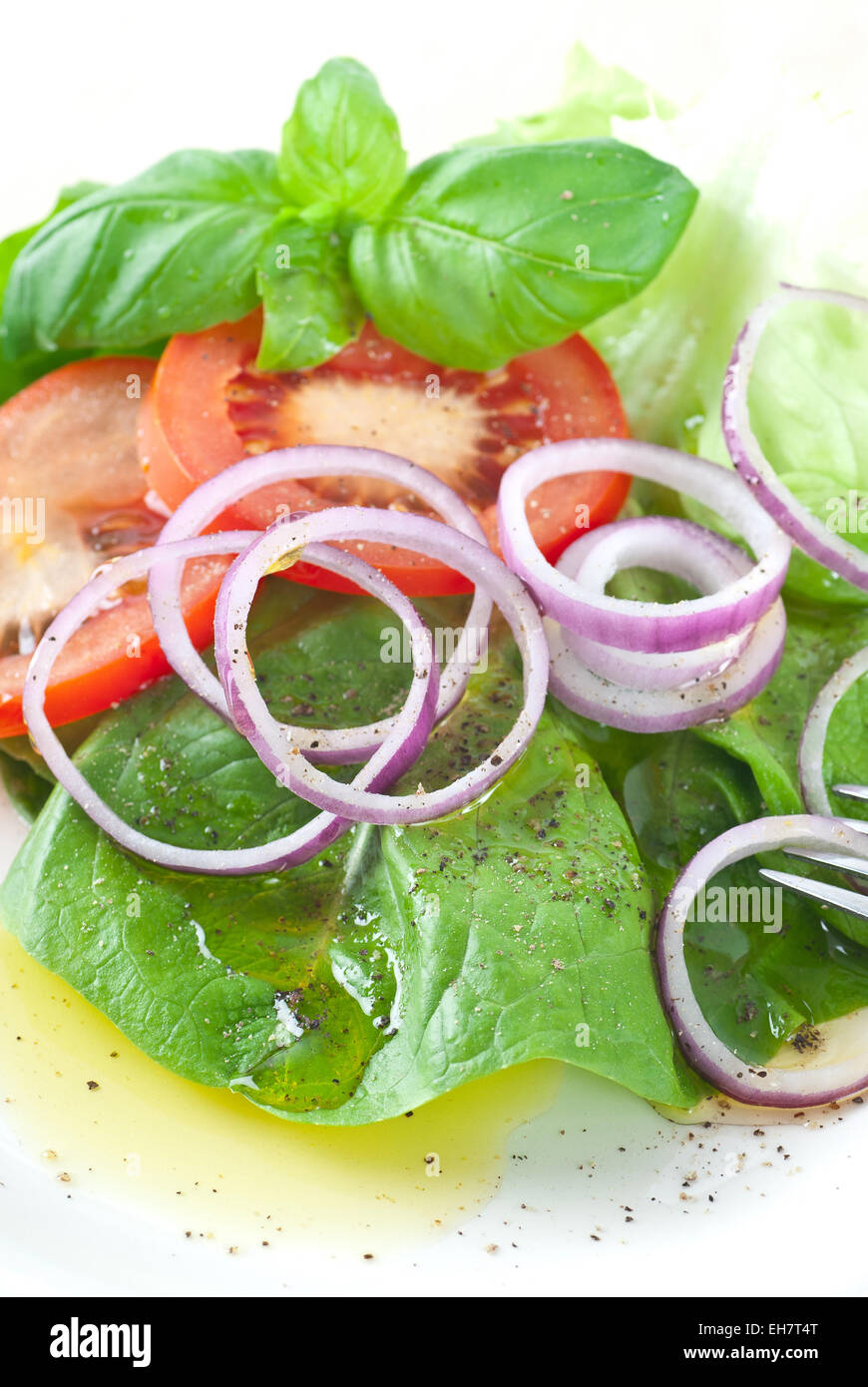Insalata con cipolla e pomodoro rosso. Servita con olio di oliva e pepe nero. Foto Stock
