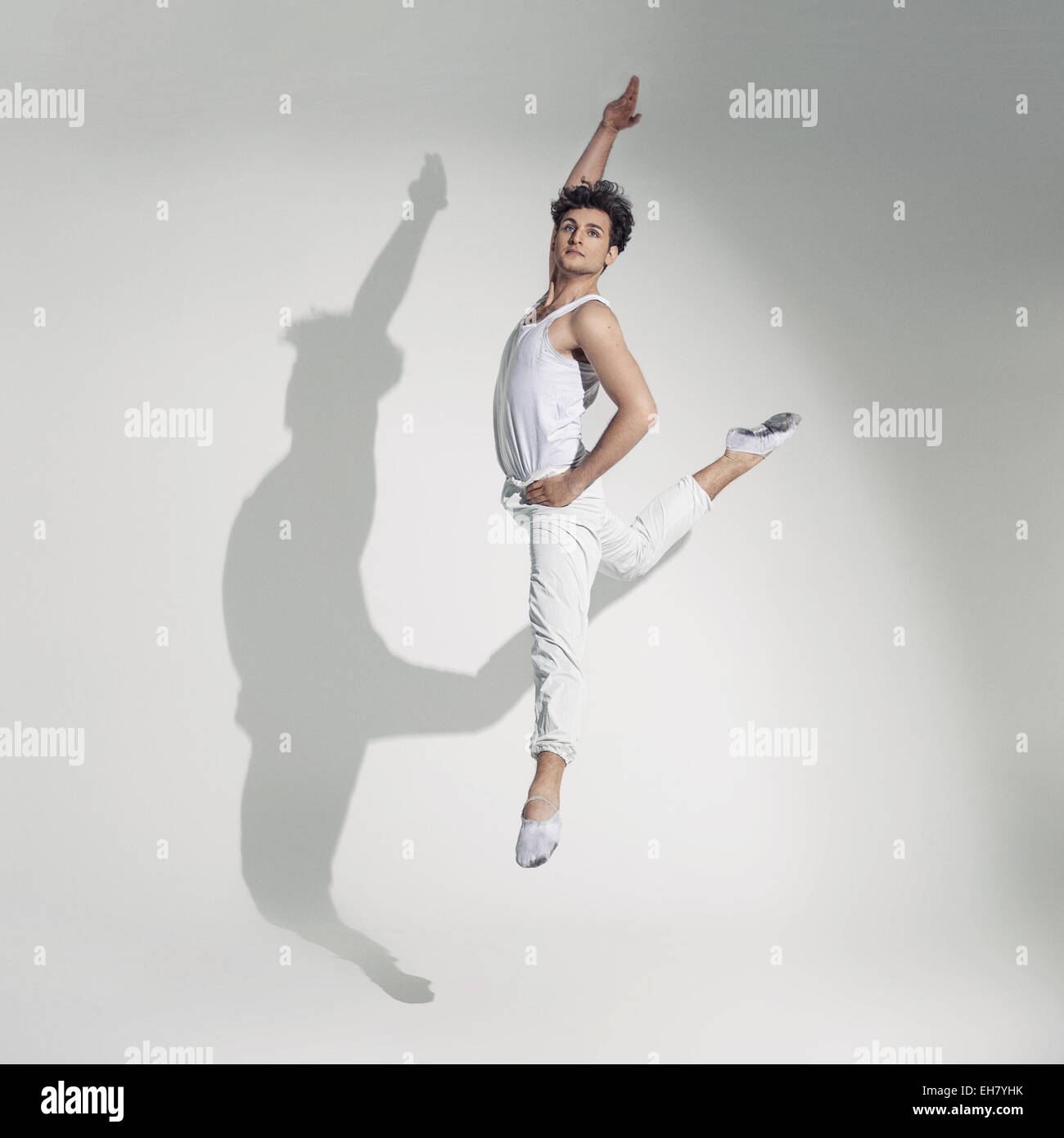 A piena lunghezza Ritratto di una giovane dancing su sfondo grigio Foto Stock