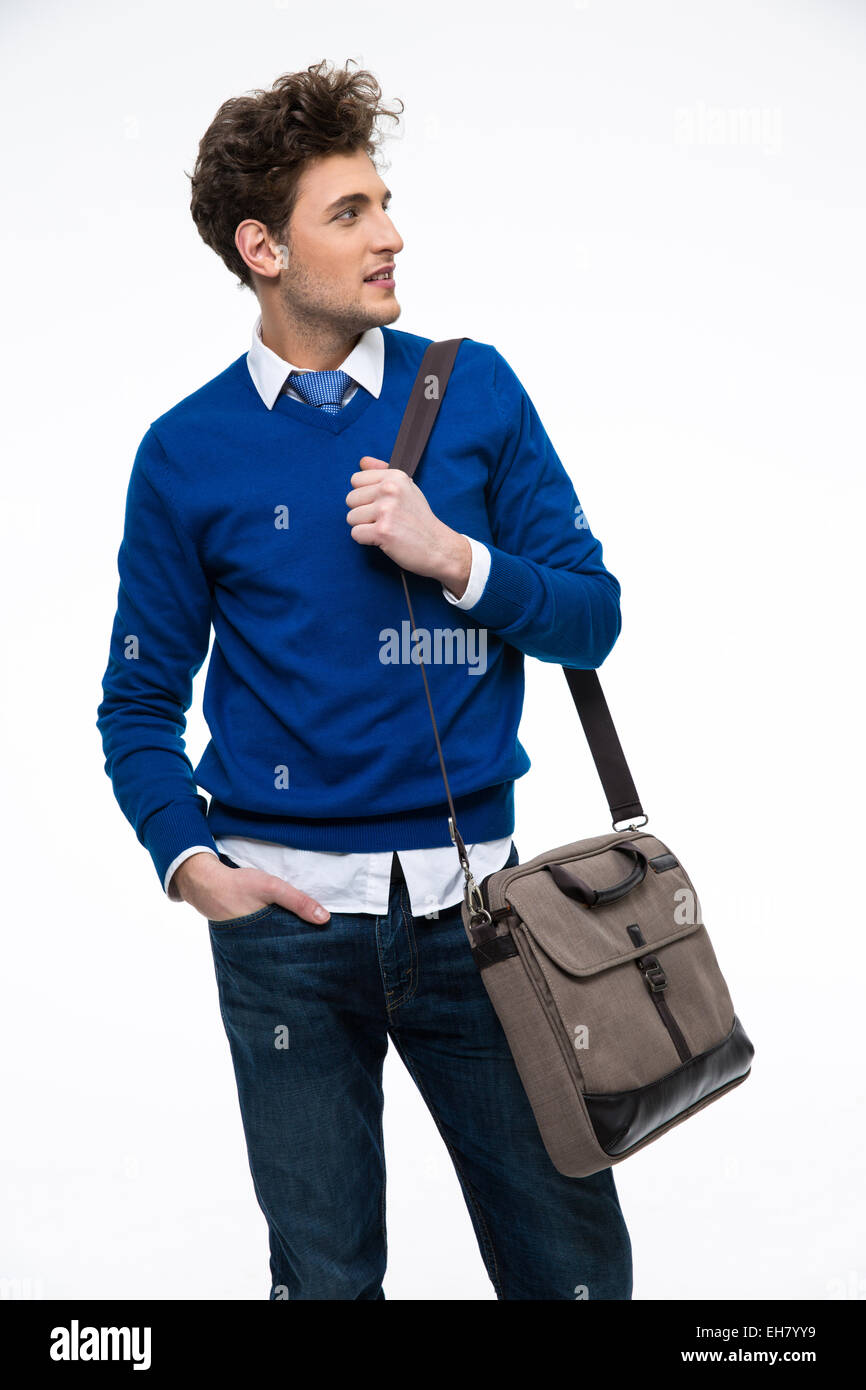 Felice giovane uomo d affari con il sacchetto che guarda lontano su sfondo grigio Foto Stock