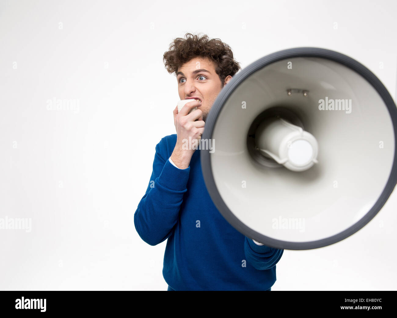 L'uomo grida attraverso il megafono su sfondo grigio Foto Stock