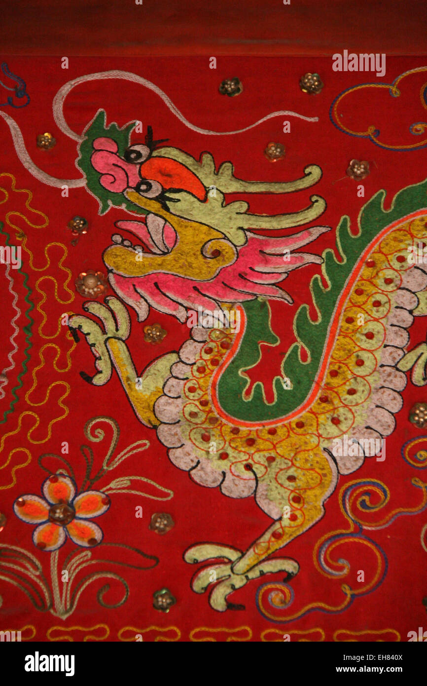 Un drago decora un tessuto appeso su una parete in un tempio buddista in Hoi An, il 14 febbraio 2009. Foto Stock