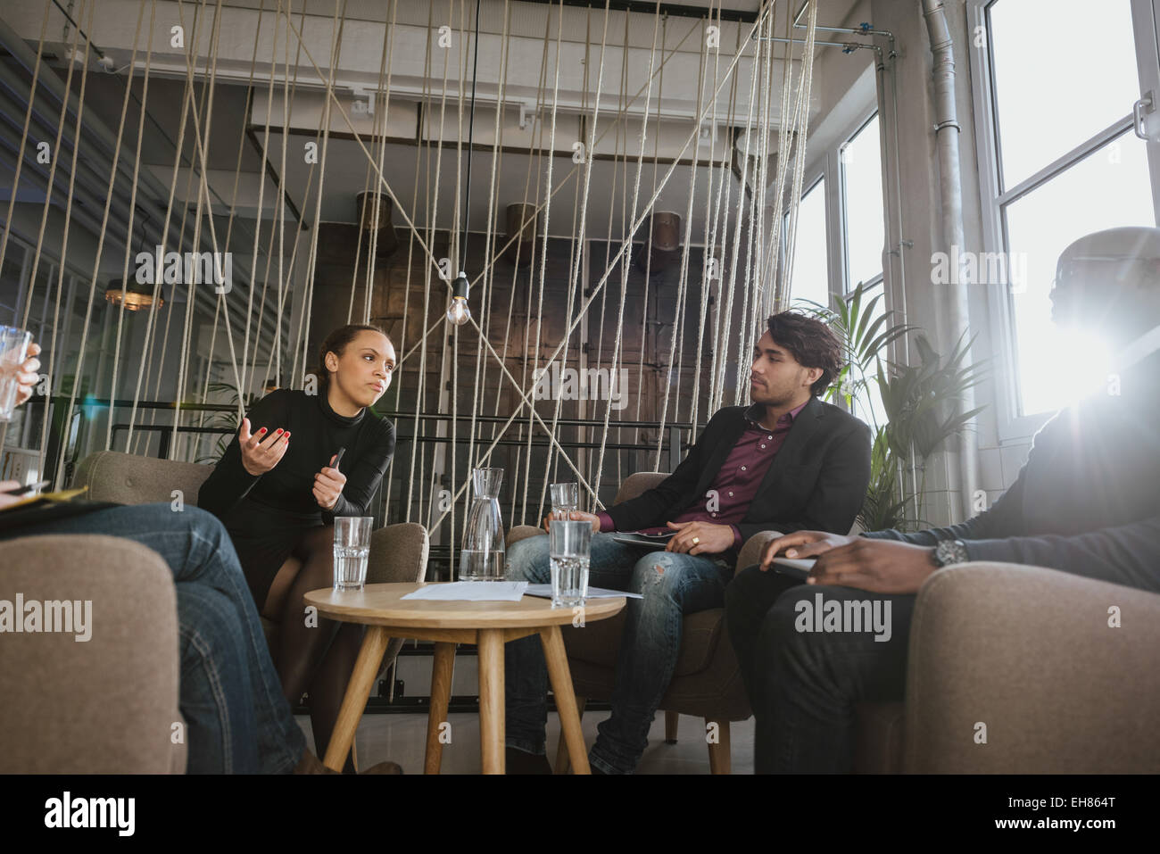 Giovane donna condividendo le sue idee durante la riunione in ufficio. Giovani creativi a discutere di un nuovo progetto. Foto Stock