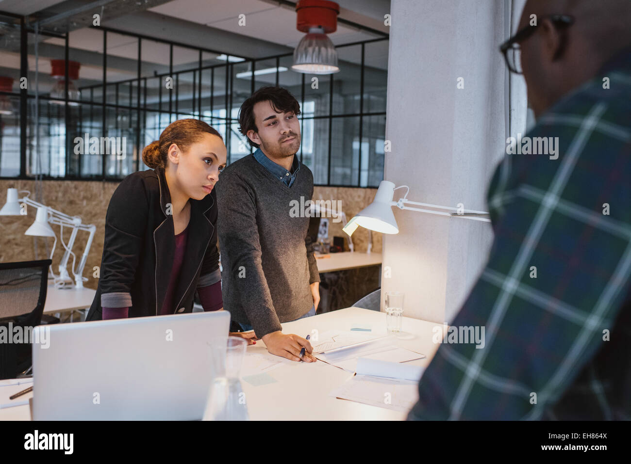 La gente di affari in piedi oltre ad una tabella che lavorano su nuove idee creative. Diversi team di giovani professionisti in una riunione a offi Foto Stock