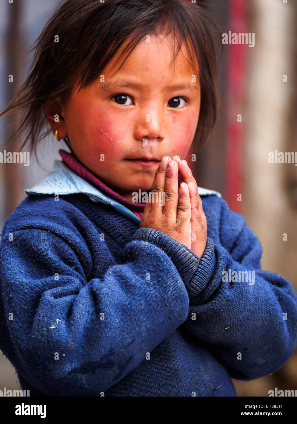 Giovane ragazza in Lo Manthang, Mustang, Nepal mette le mani nel "Namaste" posizione. Concentrarsi sulle mani. Foto Stock