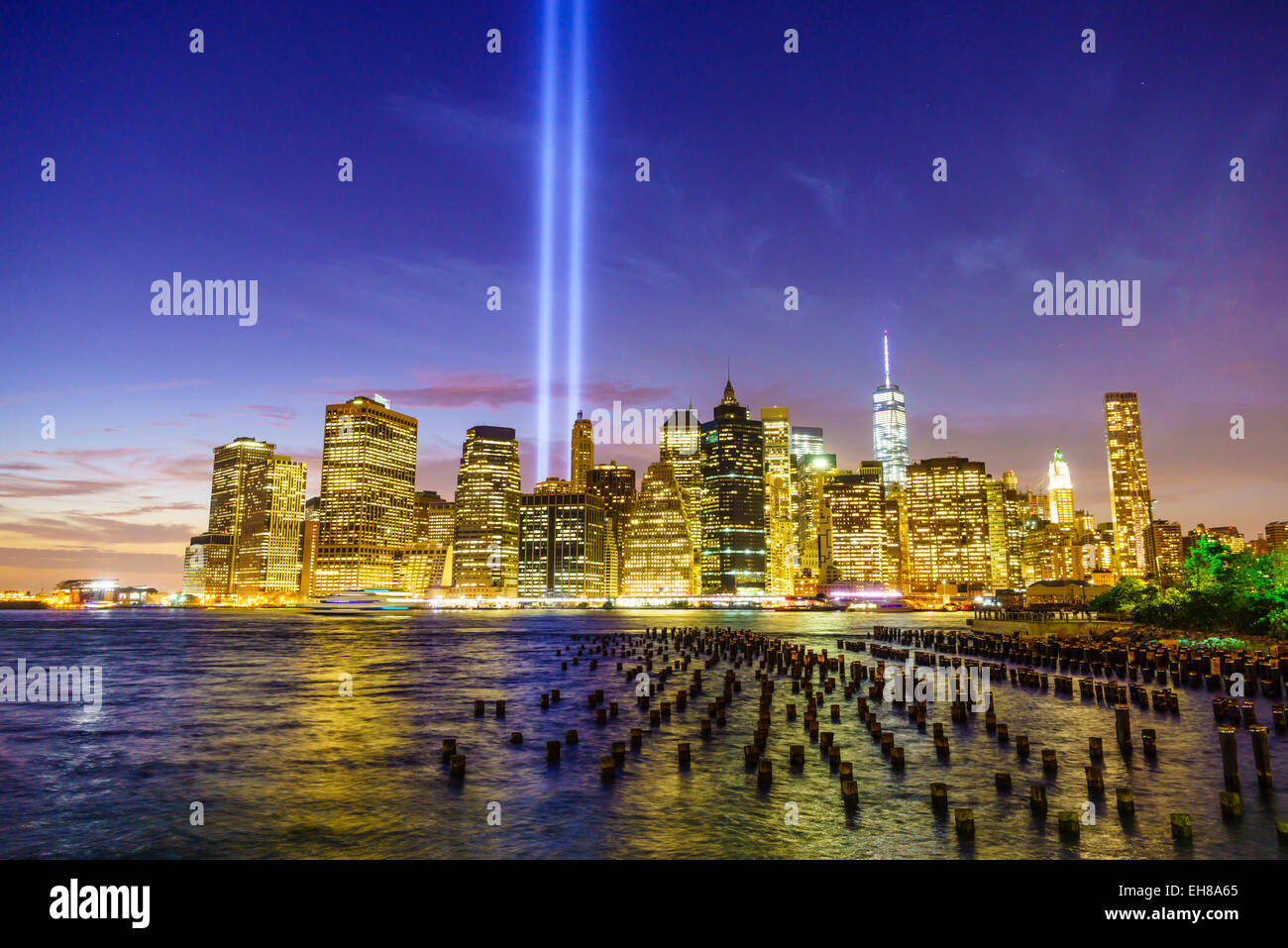 La parte inferiore di Manhattan grattacieli comprendente una World Trade Center di tutta l'East River di notte, la città di New York, New York, Stati Uniti d'America Foto Stock