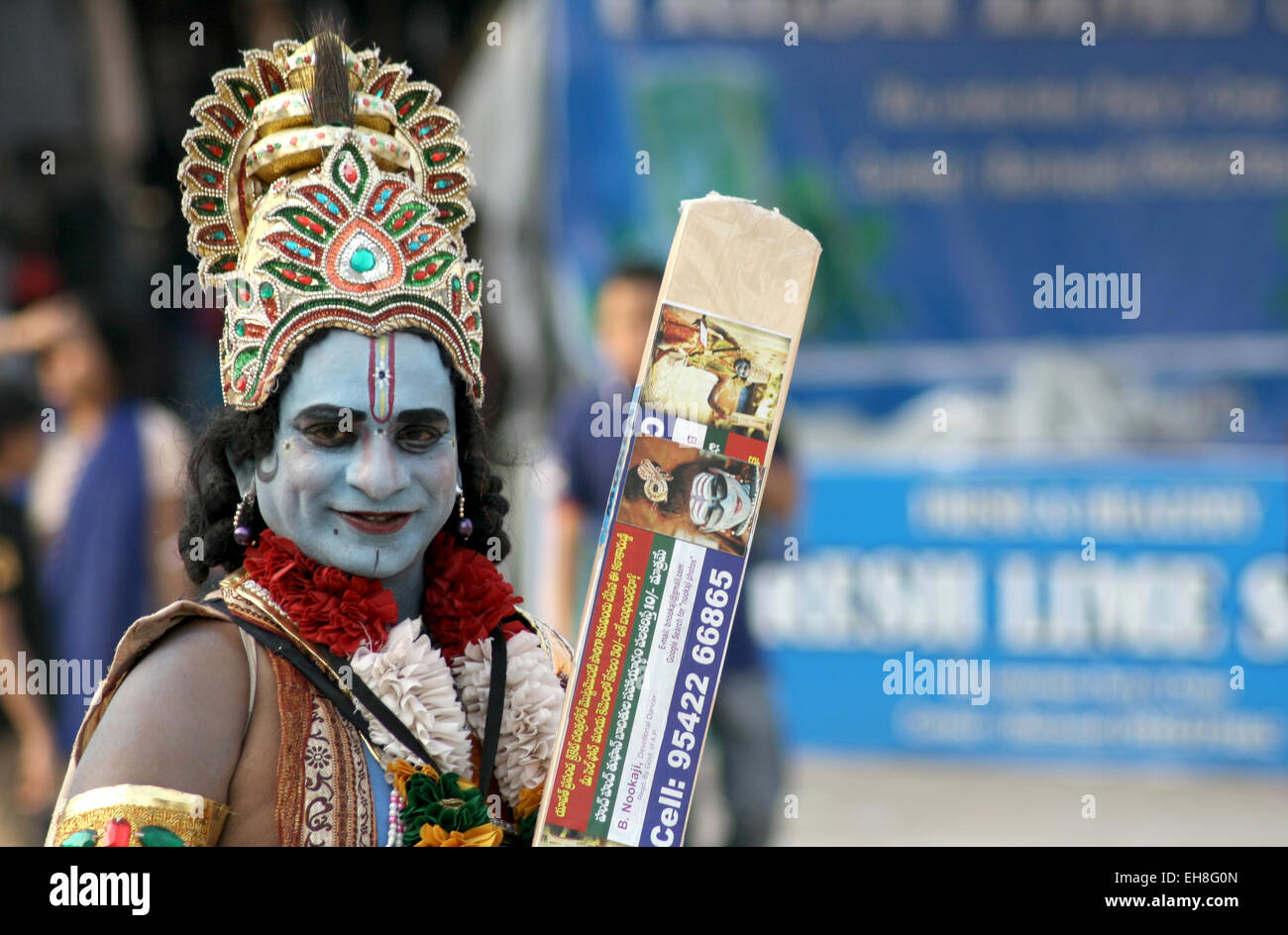 Indian uomo vestito come signore Sri Krishna ,dio indù, modo di accattonaggio o in un affollato mercato su gennaio 18,2015 in Hyderabad, India. Foto Stock