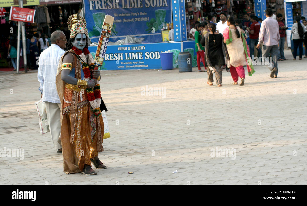 Indian uomo vestito come signore Sri Krishna ,dio indù, modo di accattonaggio o in un affollato mercato su gennaio 18,2015 in Hyderabad, India. Foto Stock