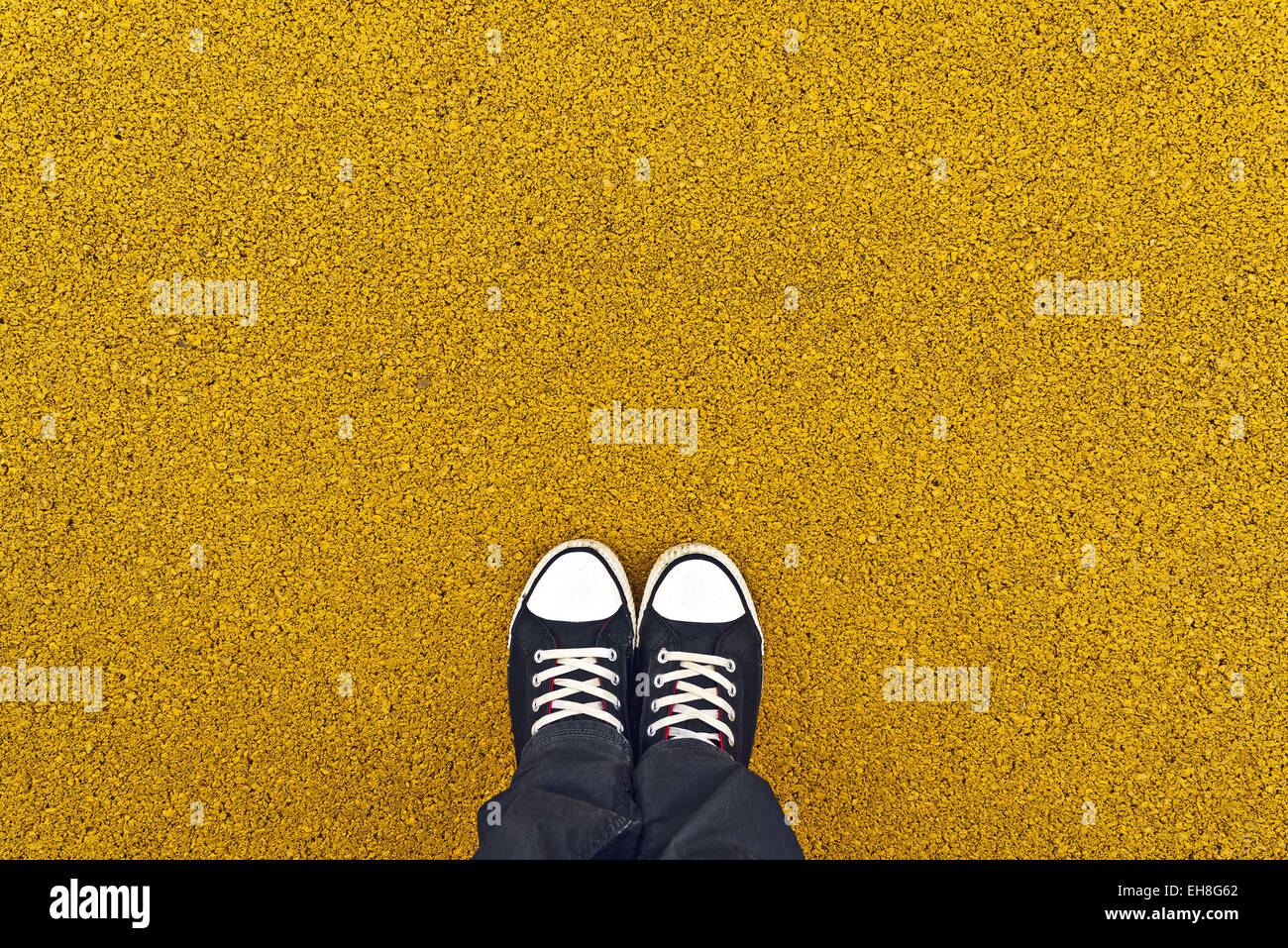 Scarpe da ginnastica da sopra. Uomo in piedi al giallo asfalto come spazio di copia Foto Stock