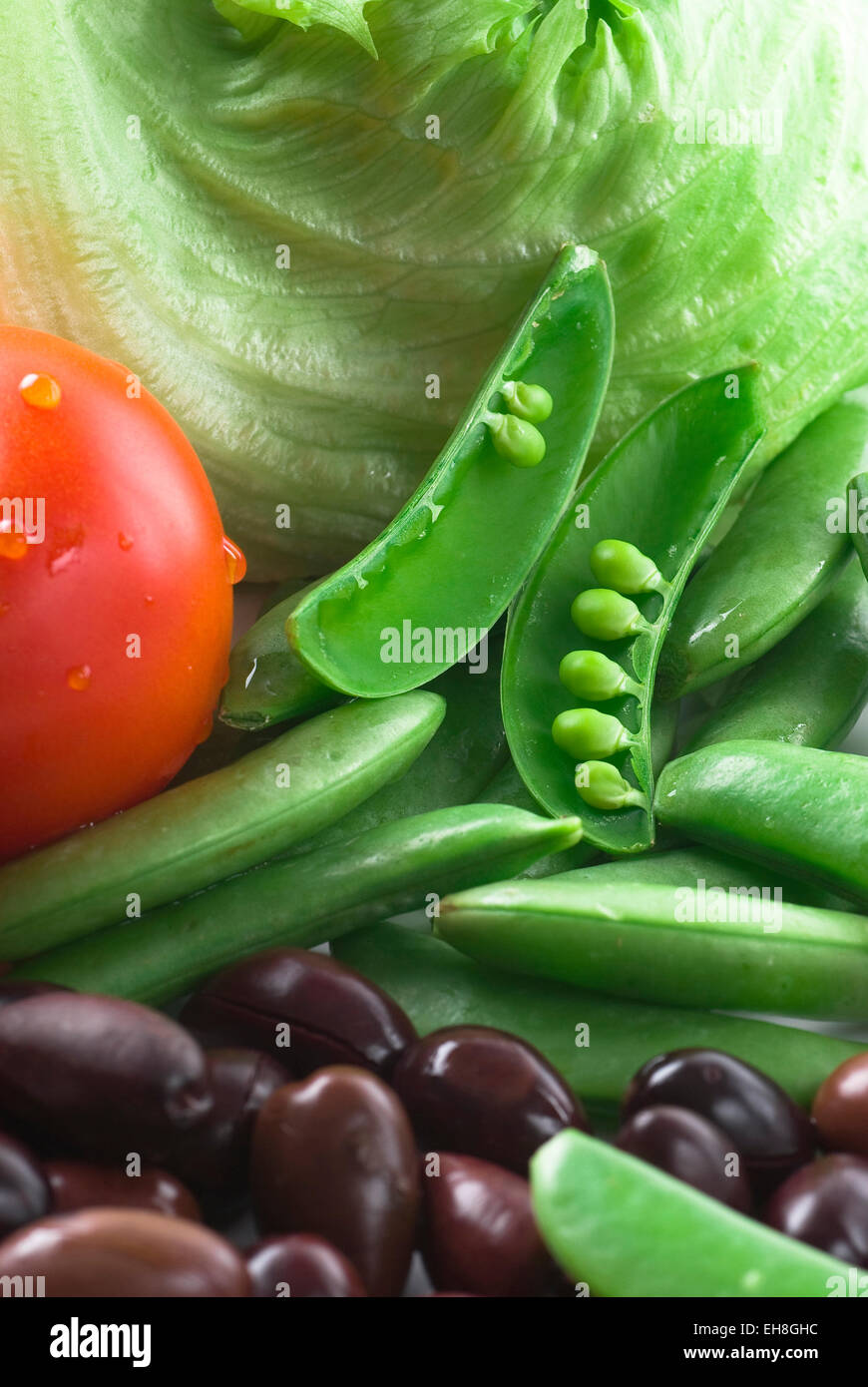 Ingredienti per insalata. Lo zucchero scatta, pomodori, lattuga e olive nere. Foto Stock