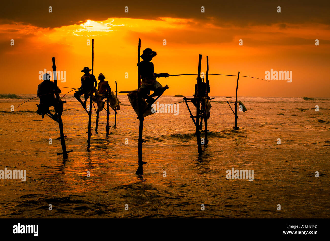 Sagome dei pescatori tradizionali al tramonto in Sri Lanka Foto Stock