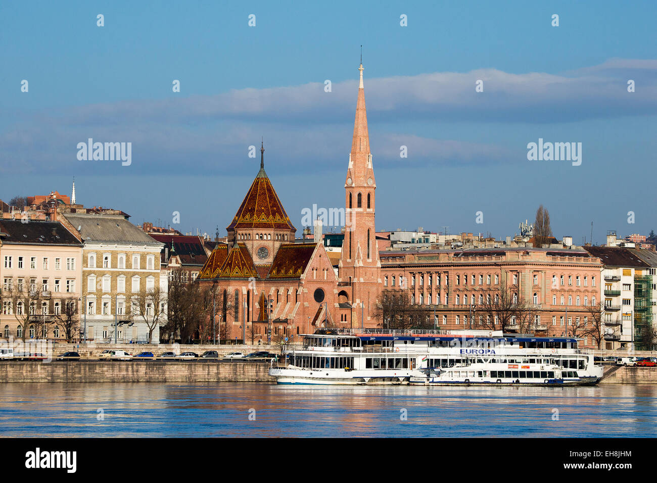 Chiesa calvinista con un fiume Danubio crociera barca in primo piano, Budapest, Ungheria Foto Stock