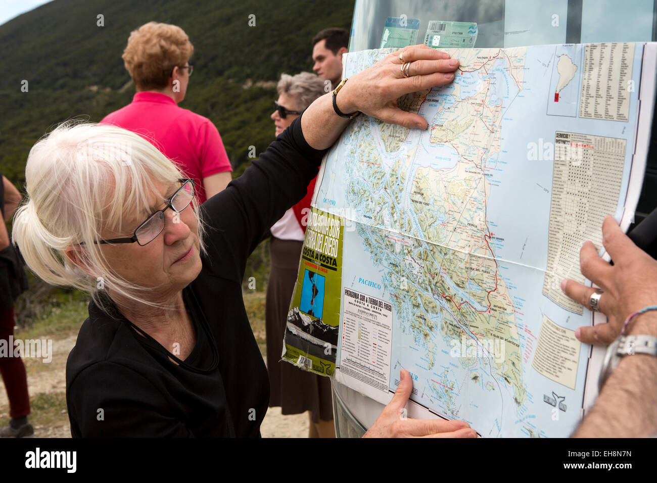 Arg051Argentina, Tierra del Fuego, Ushuaia, senior turista femminile guardando alla posizione sulla mappa Foto Stock
