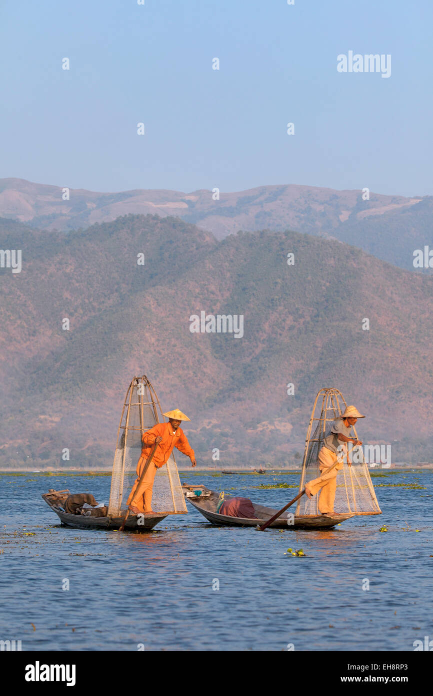 Due gambe pescatori canottaggio; Lago Inle, Myanmar ( Birmania ), Asia Foto Stock
