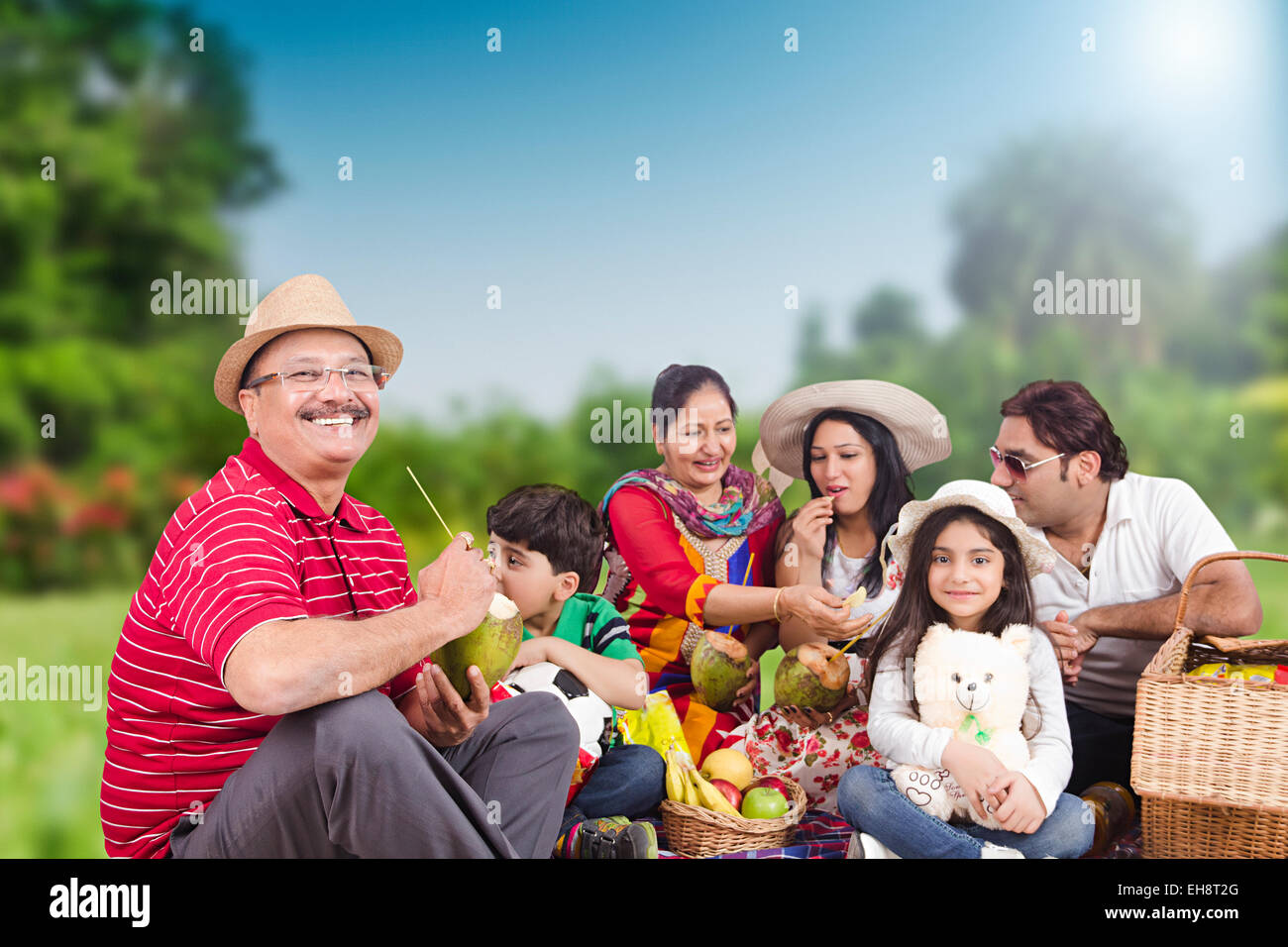 Gruppo indiano folle grand genitori park Picnic a bere frutta noce di cocco Foto Stock