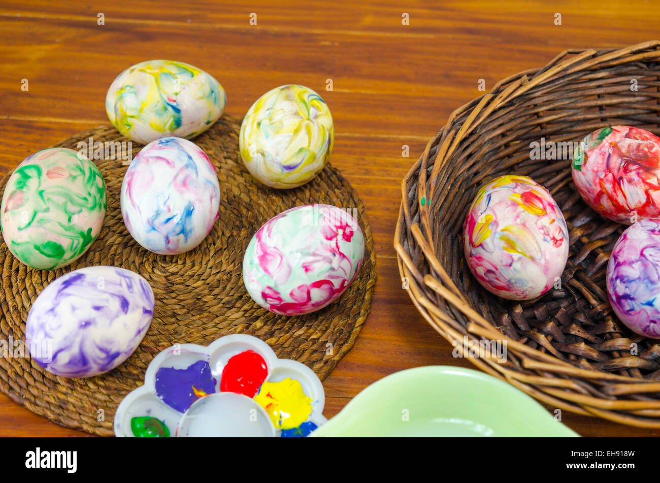 Dipinta di fresco Uova di Pasqua in un cesto su un tavolo di legno Foto Stock