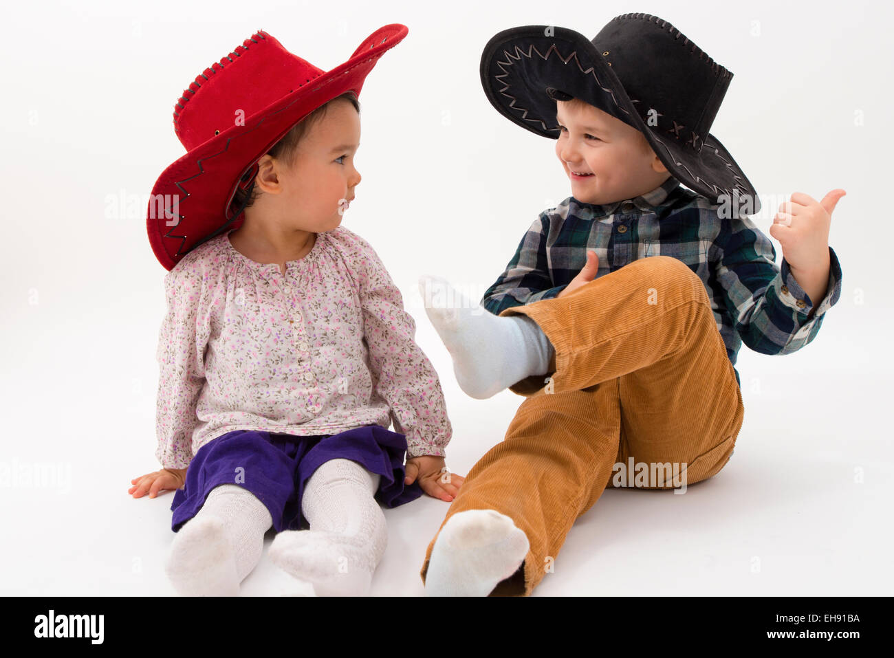 Due fratelli sorridente indossando cappelli da cowboy Foto Stock