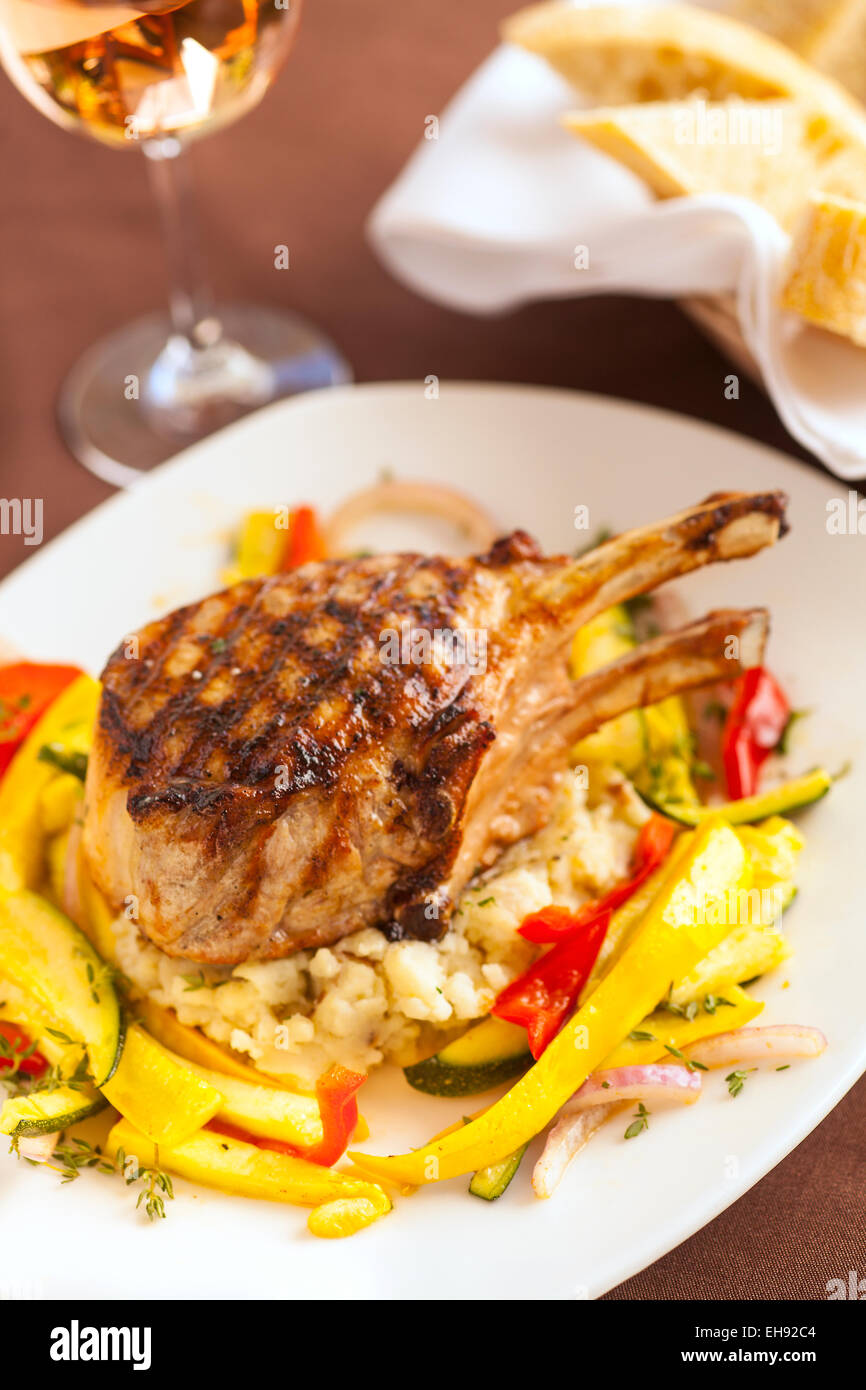 Oak grigliate di Berkshire costolette di maiale con pane e un bicchiere di vino, Paradise Cafe, Santa Barbara, California Foto Stock