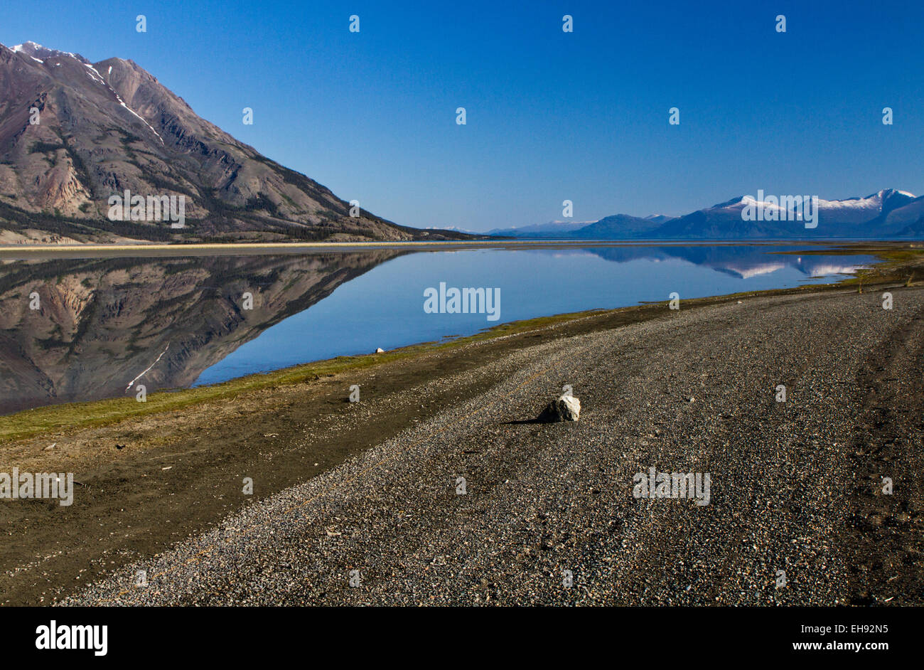 Tachal Dhal (ovini Montagna) riflettendo nel lago Kluane con la gamma di Ruby in distanza, Yukon Territory, Canada Foto Stock