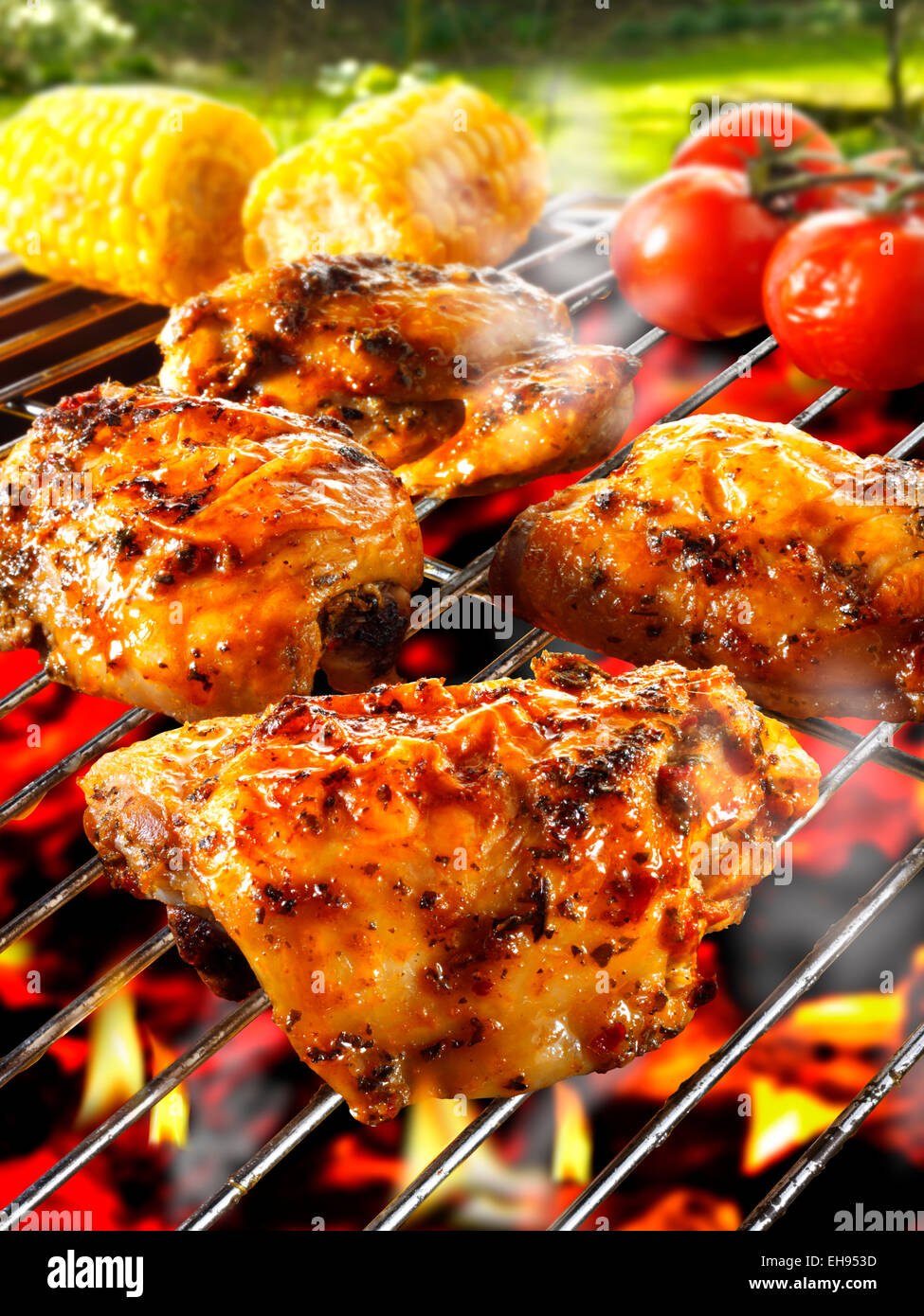 Barbecue di pollo a pezzi la cottura su un barbecue oltre le fiamme Foto Stock