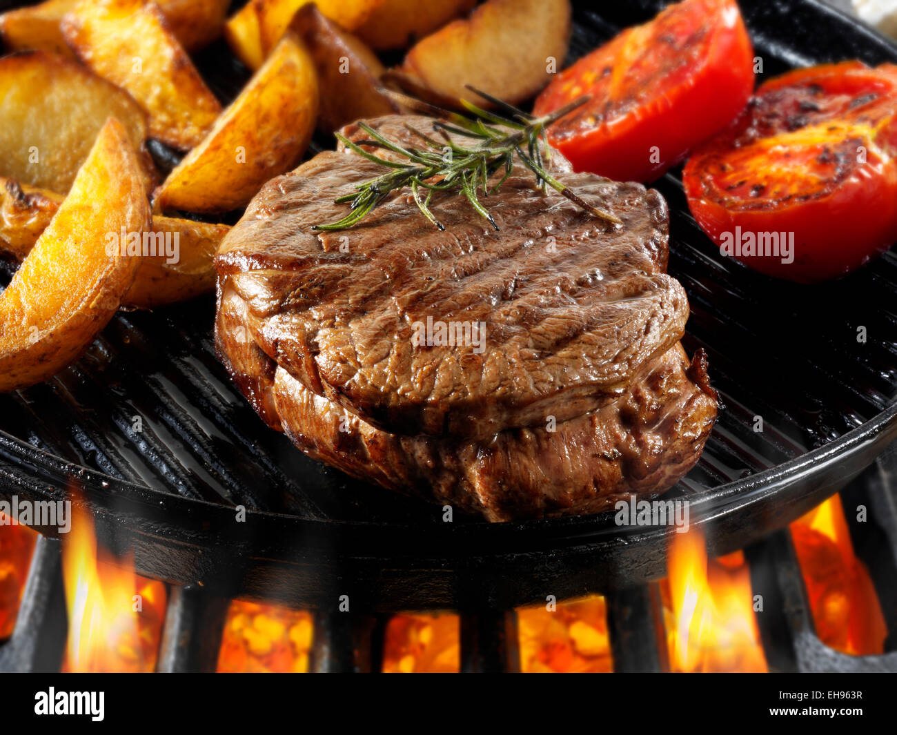 Filetto di manzo bistecche essendo pan fried su fiamme libere Foto Stock