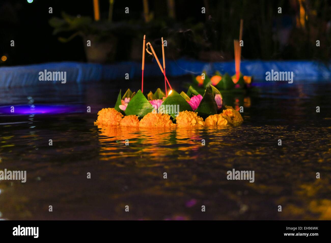Piccoli Krathong flottante con candele e fiori Foto Stock
