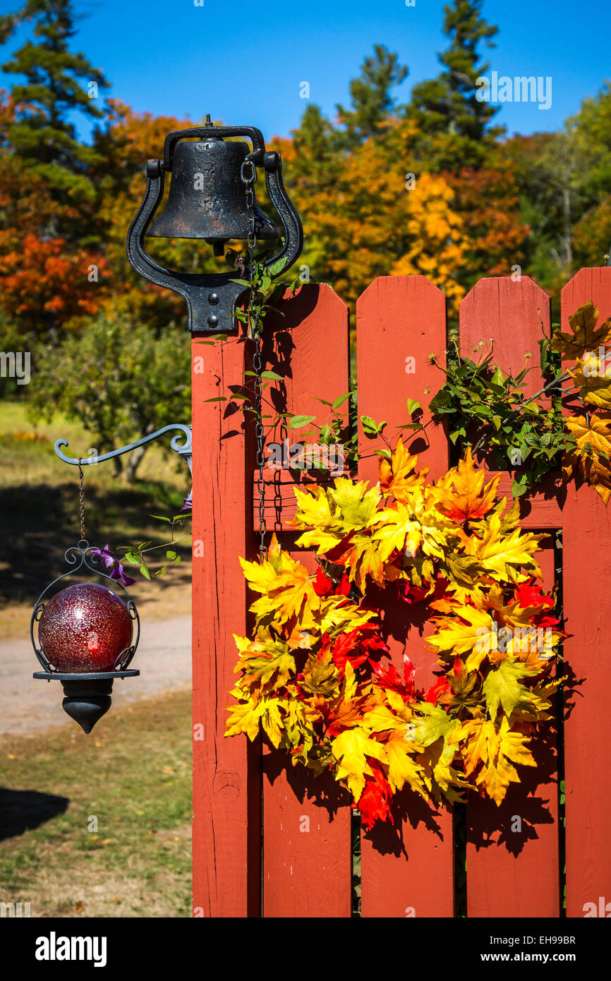 Un paese di recinzione con gate decorativo wreathe caduta in Bayfield, Wisconsin, Stati Uniti d'America. Foto Stock
