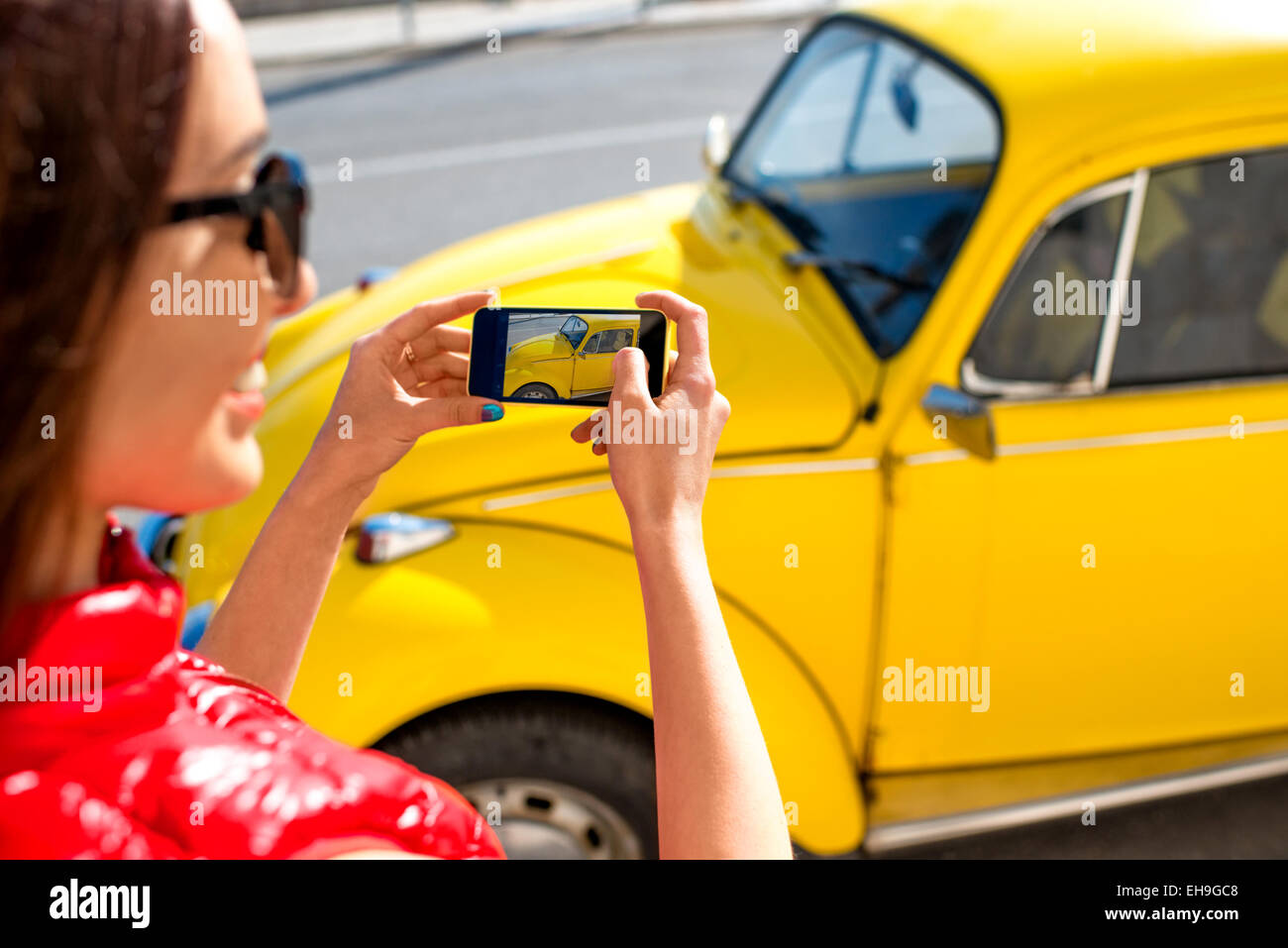 Donna fotografare la vecchia auto di colore giallo Foto Stock