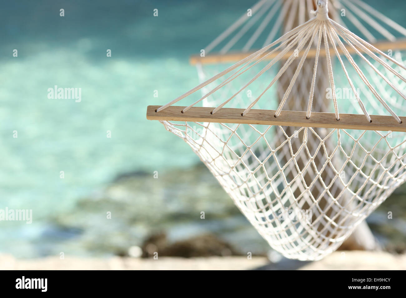 Concetto di viaggio con una amaca in una spiaggia tropicale con acqua turchese in background Foto Stock