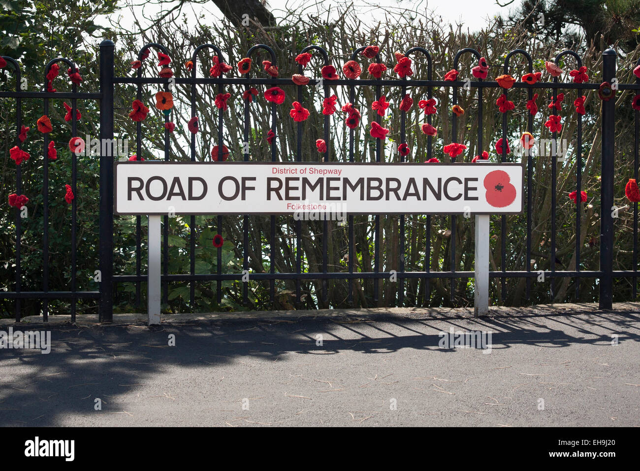 Maglia papaveri commemorative sulle ringhiere sulla strada del ricordo che conduce al WW1 Memorial Arch in Folkestone, Kent Foto Stock