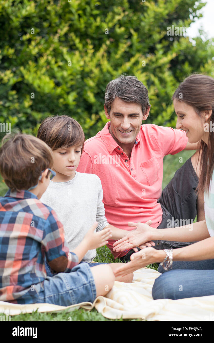 Famiglia la riproduzione di giochi a mano insieme al picnic Foto Stock