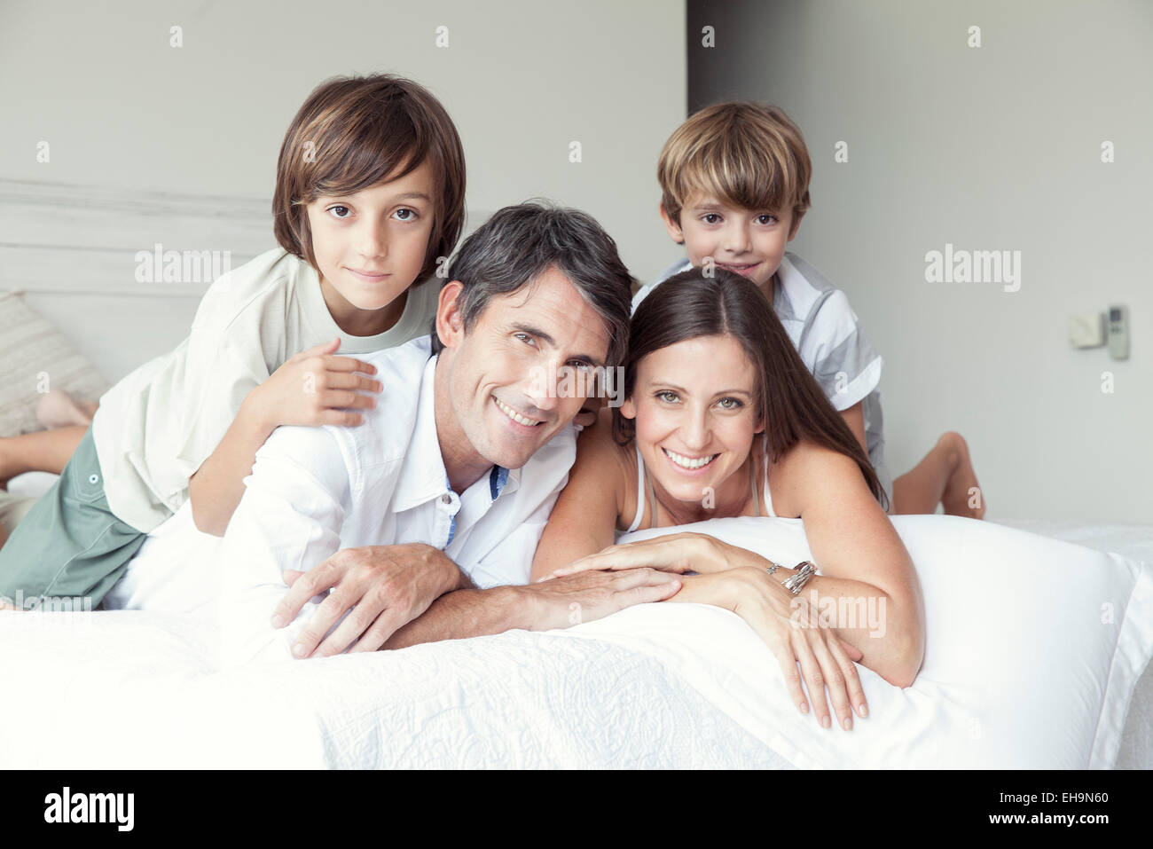 Famiglia giacente sul letto, ritratto Foto Stock