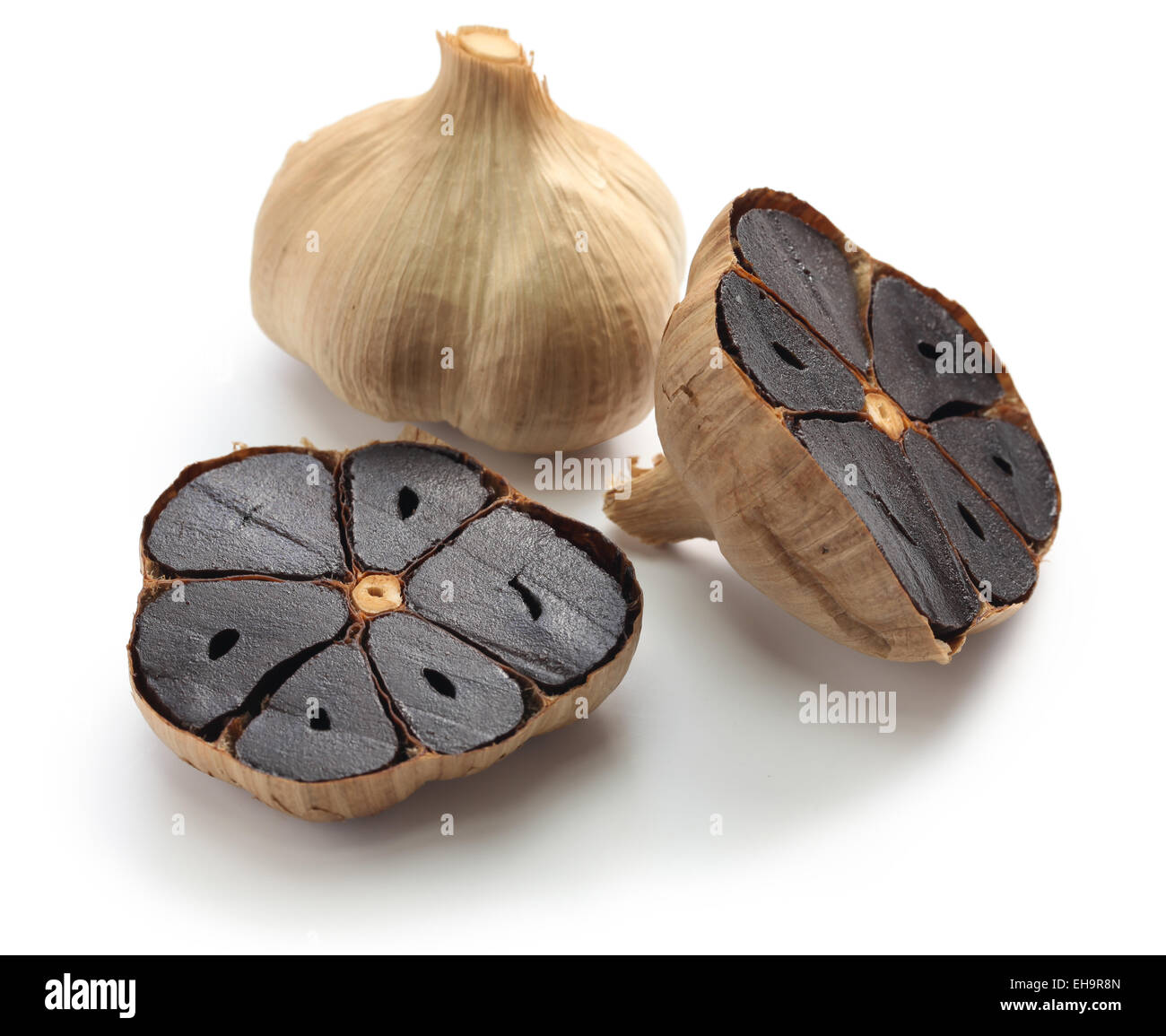 Nero bulbi di aglio e chiodi di garofano su sfondo bianco Foto Stock