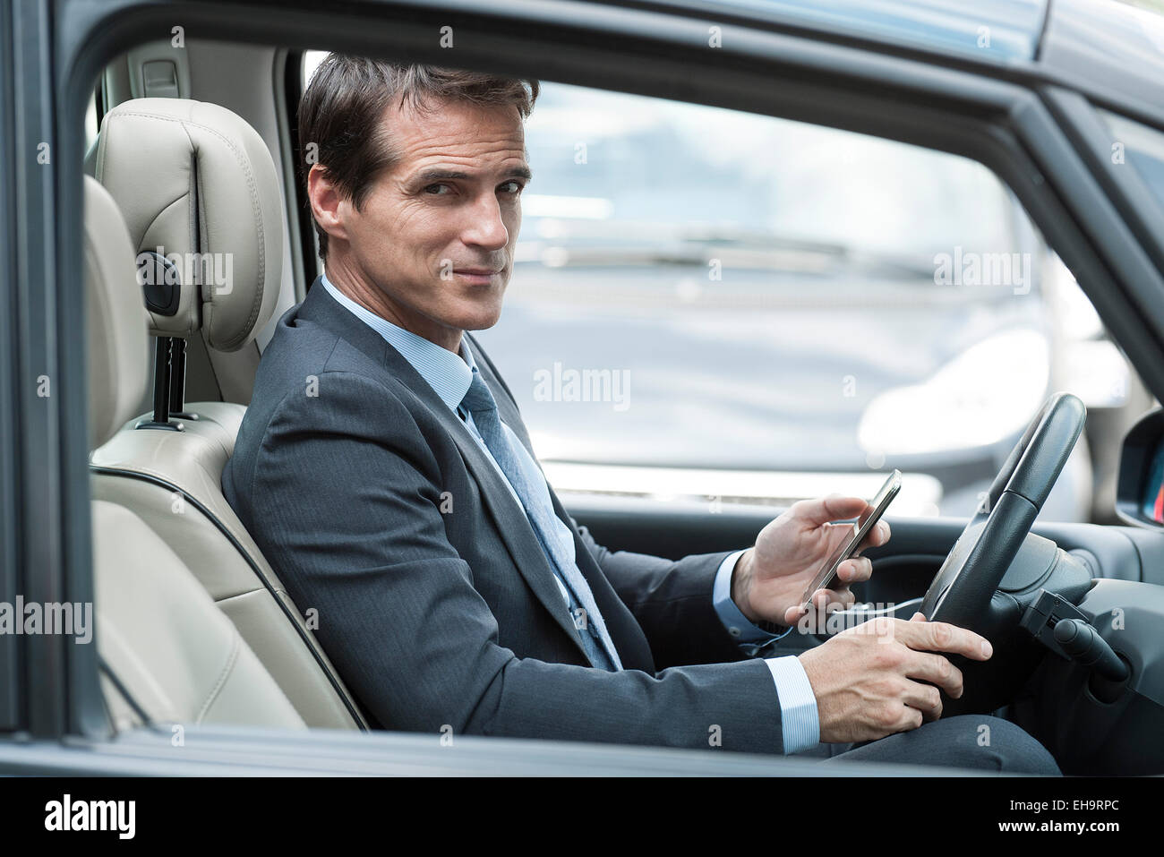 L'uomo texting mentre si guida auto Foto Stock