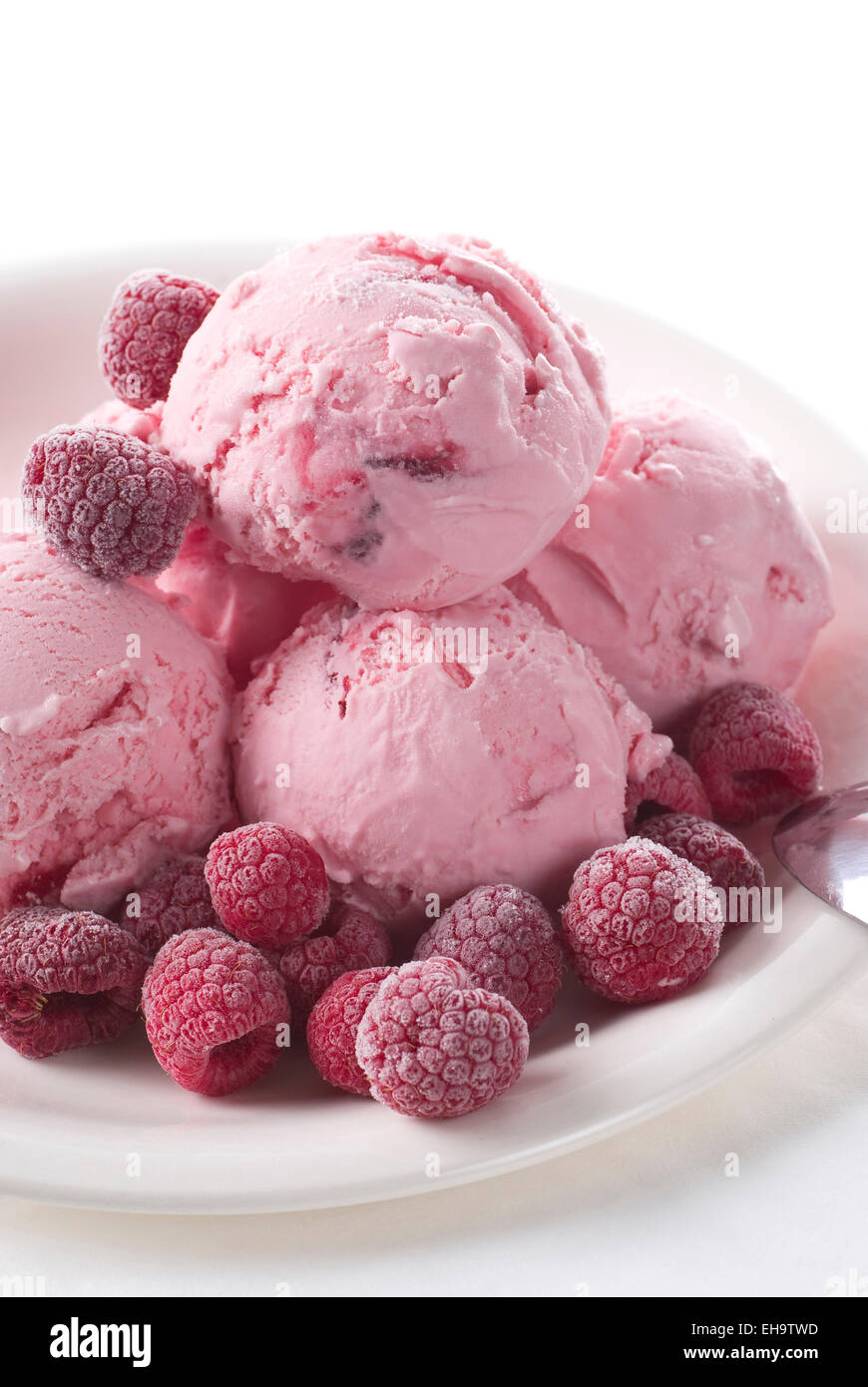 Gelato al lampone scoop con lamponi congelati su una piastra. Foto Stock