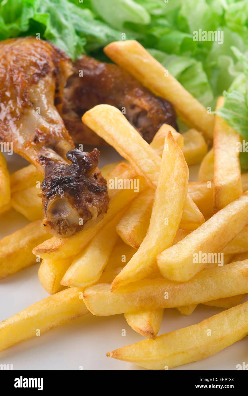 Gamba di pollo con patate fritte e insalata verde. Foto Stock