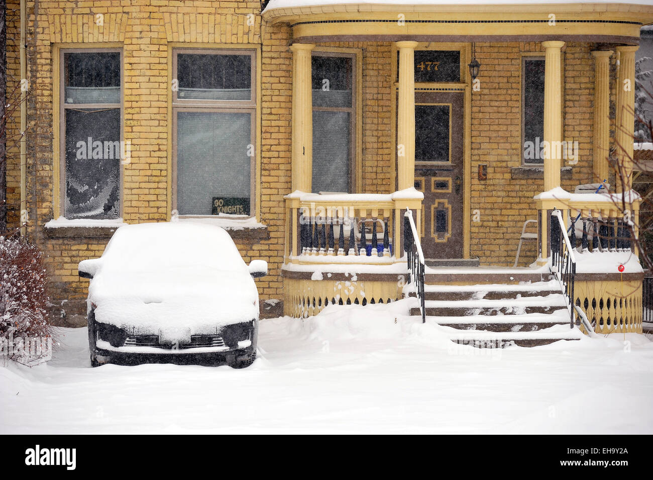 Una coperta di neve auto parcheggiate in un vialetto di casa in Canada. Foto Stock