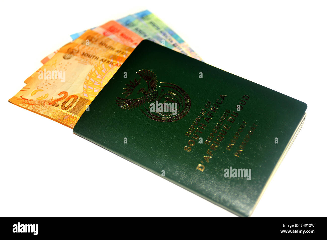Immagine di un passaporto sud-africano pieno di note di Rand fotografata in uno studio contro uno sfondo bianco. Foto Stock