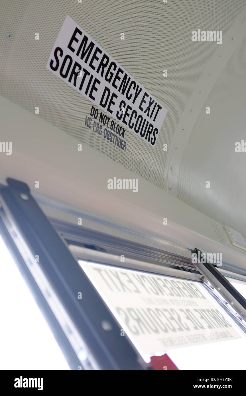 Bilingue in uscita di emergenza segno sul soffitto di un bus canadese. Foto Stock